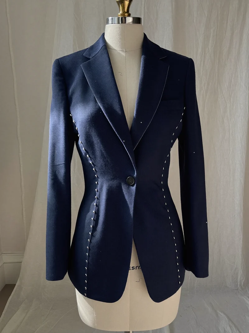 Marineblauer Blazer an der Schneiderpuppe, mit Kreidelinien und Stecknadeln an den Seitennähten